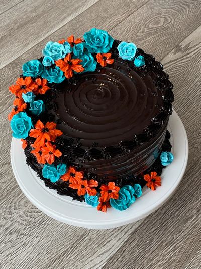 Side view of Chocolate cake with teal and orange flowers