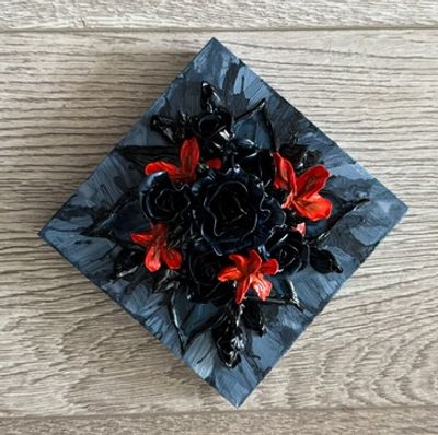 A dark square artwork featuring black roses with vibrant orange flowers on a textured background.