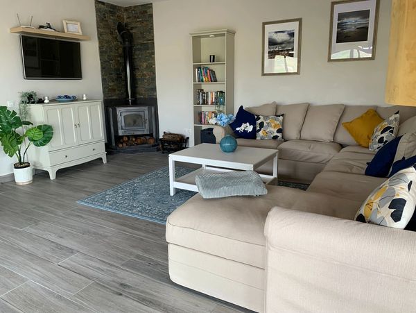 A living room interior with a corner sofa, a TV and a fireplace