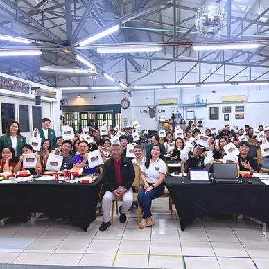 Group photo of people holding certificates indoors.