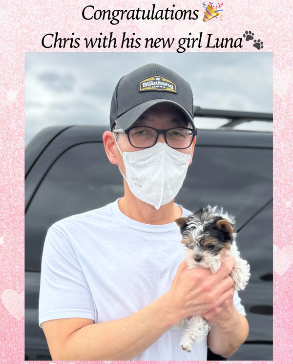 Chris holding his new puppy Luna, celebrating a happy moment.