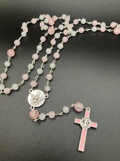 Rosary beads with pink and white beads and a pink cross.