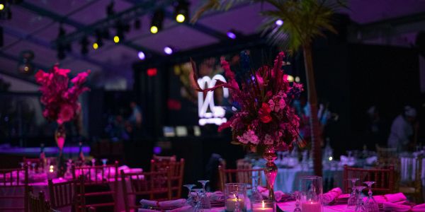 Elegant event setup with floral centerpieces and mood lighting.