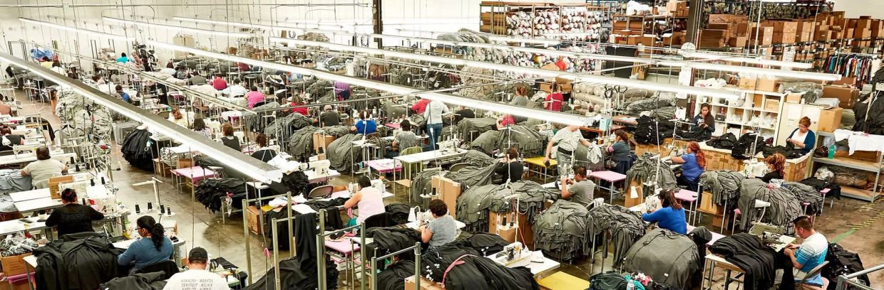 Busy textile factory with many workers sewing garments.