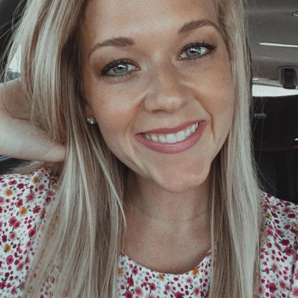Smiling woman with blonde hair and floral top.