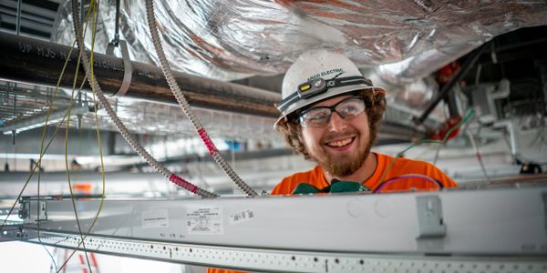Pre-apprentice electrician installing lighting and electrical fixture