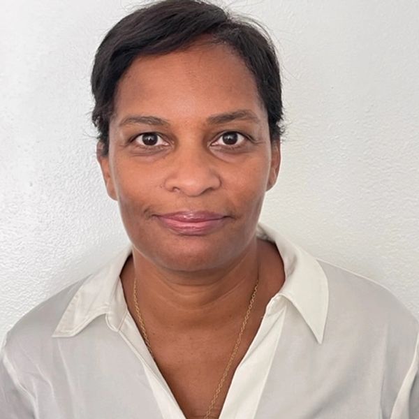 Portrait of a woman in a white blouse against a plain white background.