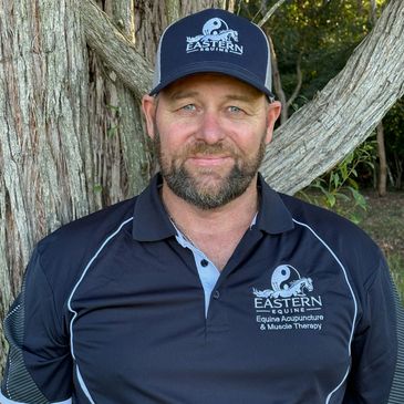 Man wearing a cap and polo shirt with Eastern Equine logo outdoors.