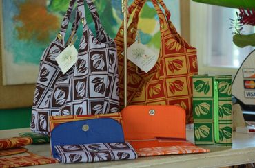 Colorful patterned bags and wallets displayed on a table.