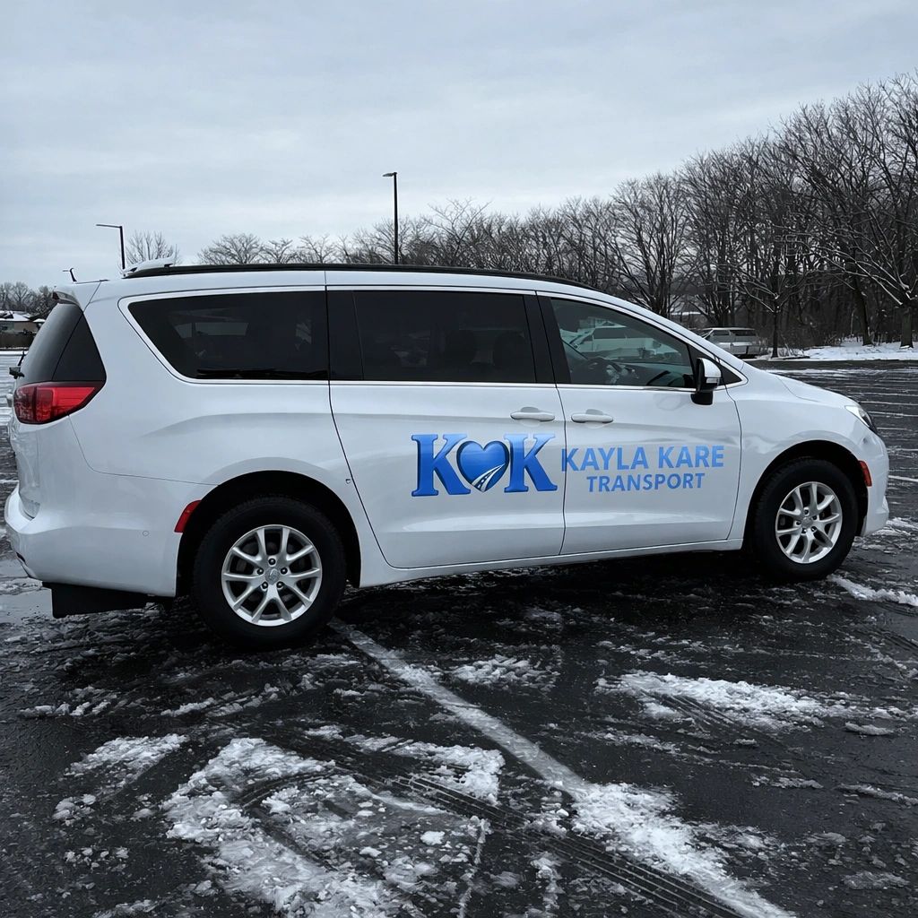 White van with Kayla Kare Transport logo parked on snowy asphalt.
