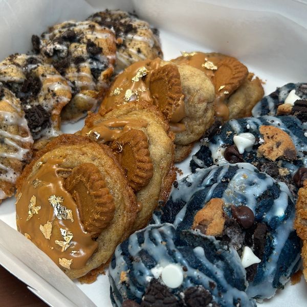 Assorted cookies with various toppings in a box.