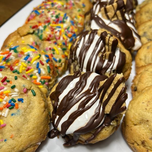 Assorted decorated cookies with sprinkles and chocolate drizzle.