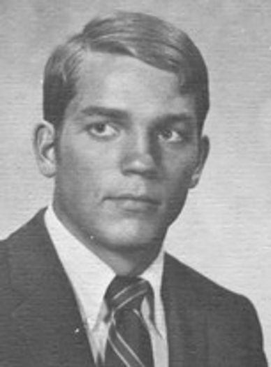 Black and white portrait of a young man in a suit and tie.