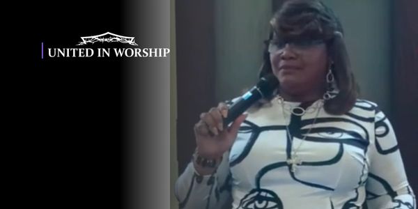 Woman holding a microphone during a worship event.