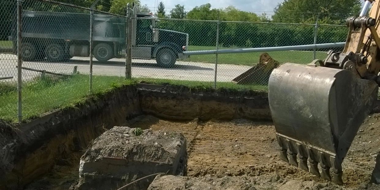 Excavator digging a section of soil into a dump truck