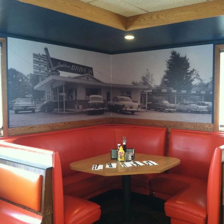 Retro diner booth with vintage mural.