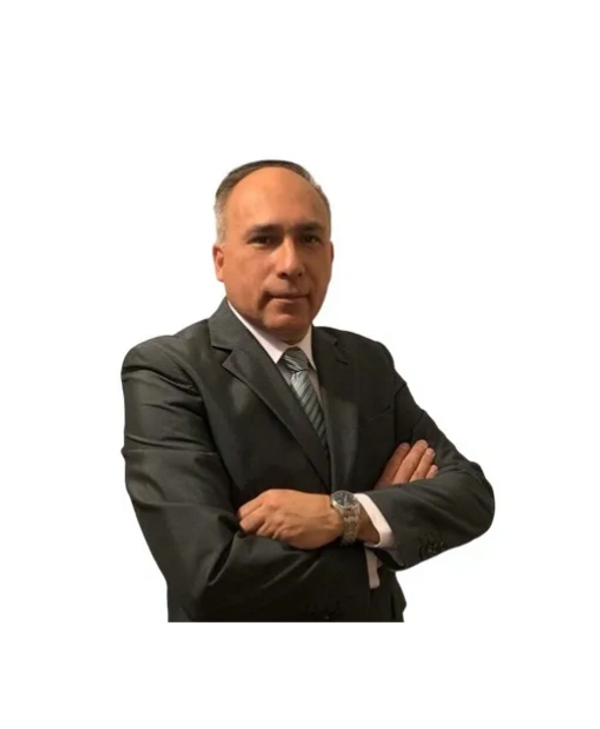 Man in a dark suit with arms crossed posing confidently.