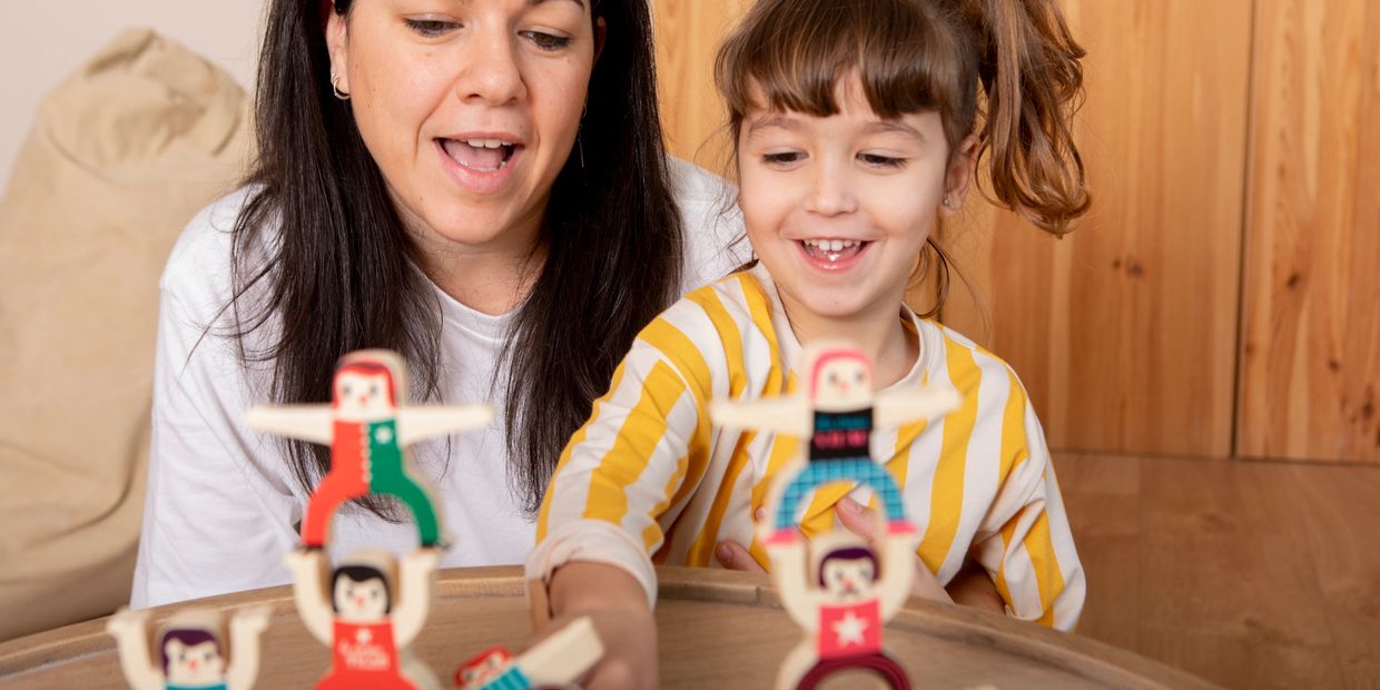 A mother and daughter playing a balancing toy game.