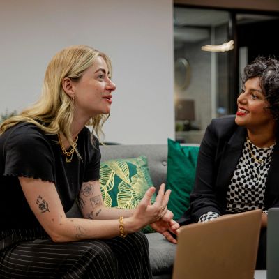 Two women engaged in a lively conversation on a couch.