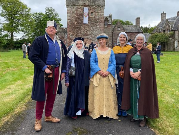 A group pf 5 people wearing medieval costume in front of Hunterston Castle.