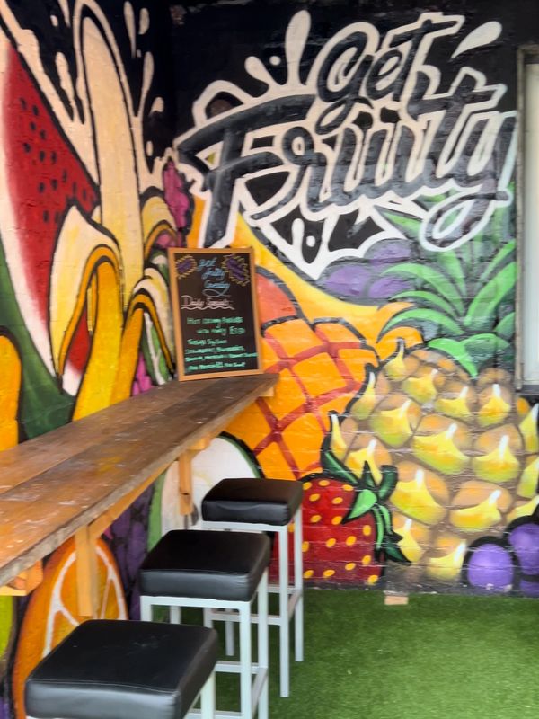 Interior of get fruity Coventry with a graffiti style mural of colourful fruits
