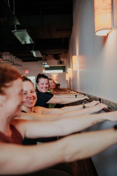 Group exercise class reaching forward with arms.