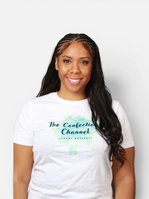 Smiling woman with long braided hair wearing a white t-shirt with 'The Confection Channel' logo.