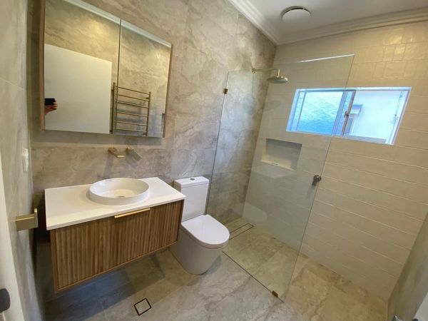 Timberline semi-insert basin vanity with semi-insert shaving cabinet and wall-in shower.