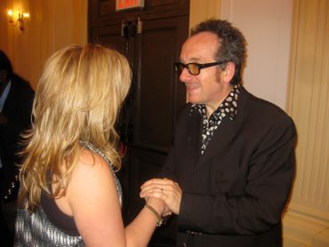 Two people holding hands and conversing indoors.