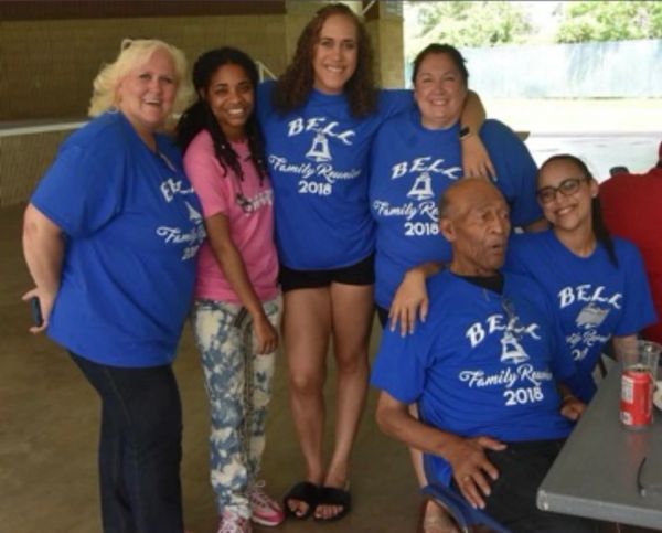A group of six people at a Bell family reunion in 2018, wearing matching blue shirts.