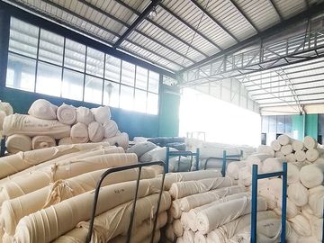 Warehouse storing large rolls of circular knitted fabric.