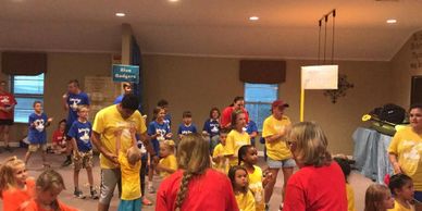 Large groups of children and adults singing during vacation bible school.