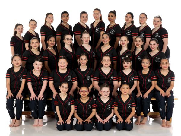 Group photo of young dancers in black and red uniforms.