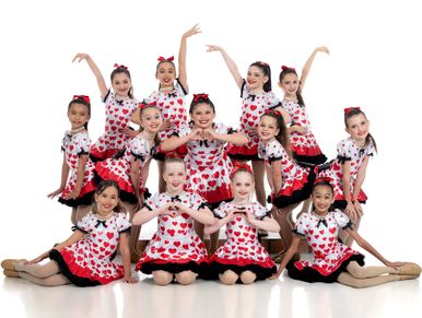 Ballet students in matching red tutus posing after a recital

