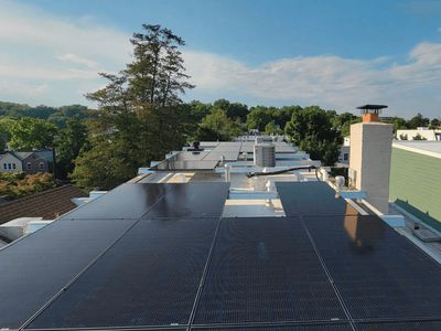 Solar panels installed on a flat rooftop under a clear sky.