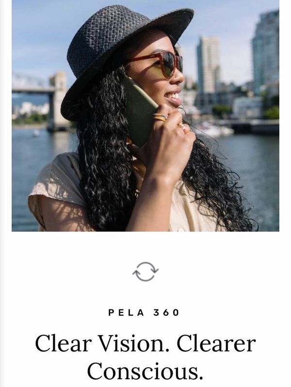 Woman with sunglasses and hat talking on phone near water.