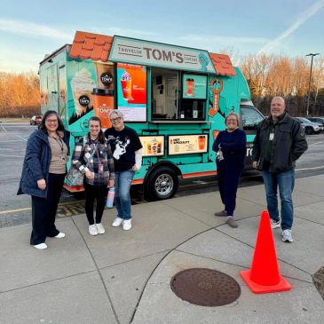 Five people stand in front of Tom's coffee truck.