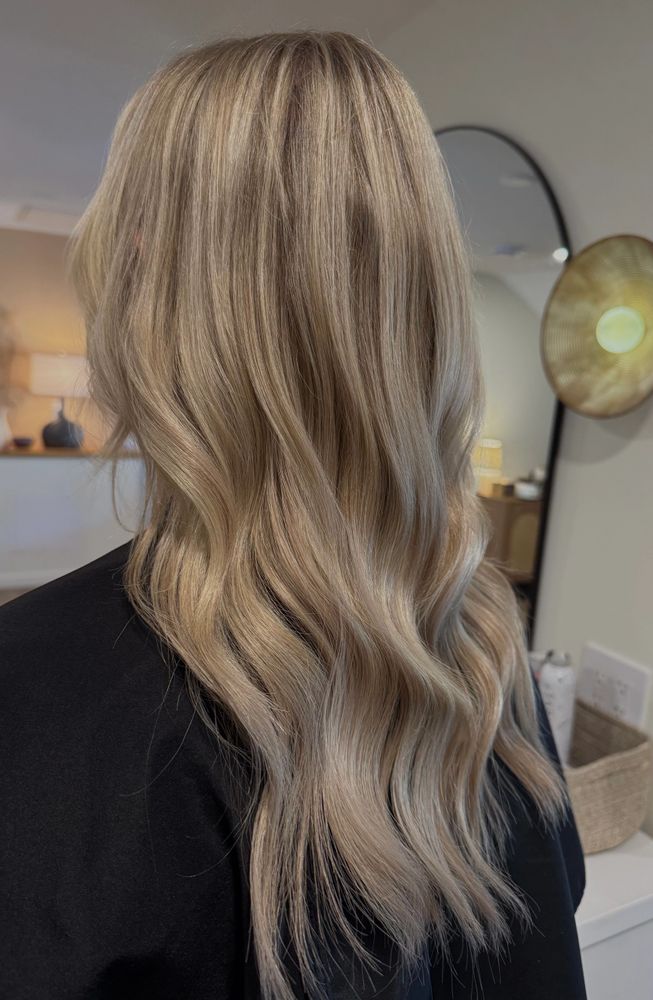 Stack of books next to pencils in a holder and a camera.