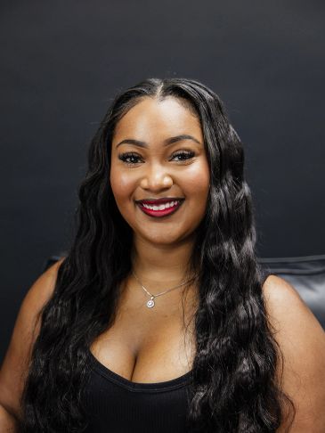 Smiling woman with long black hair and red lipstick.