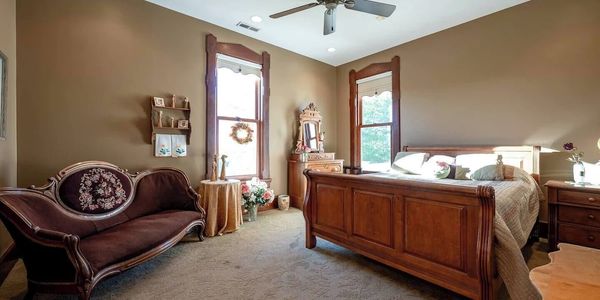 Cozy bedroom with vintage wooden furniture and floral decor.
