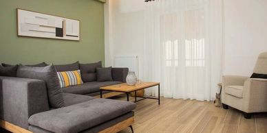 Modern living room with gray sectional sofa and wooden coffee table.