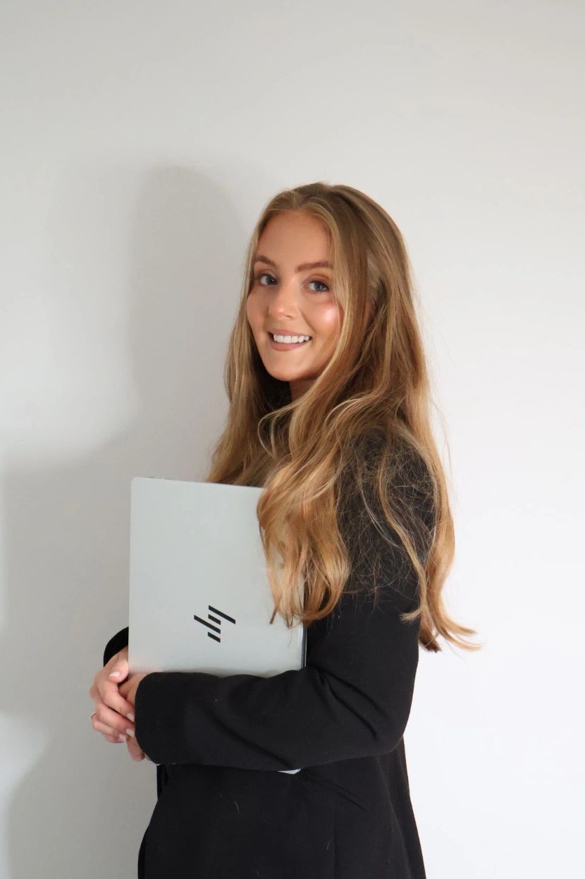 Smiling woman holding a laptop.