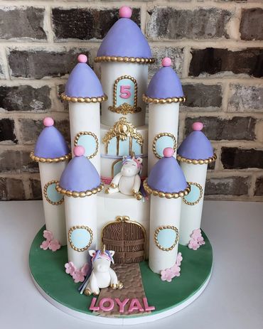 2 tiered unicorn castle cake with turrets 