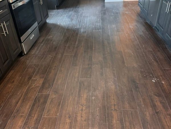 Dark wood flooring in a modern kitchen with stainless steel appliances.