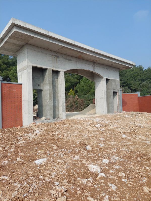 Betondan yapılmış bir giriş kapısı ve kırmızı tuğla duvarlar.