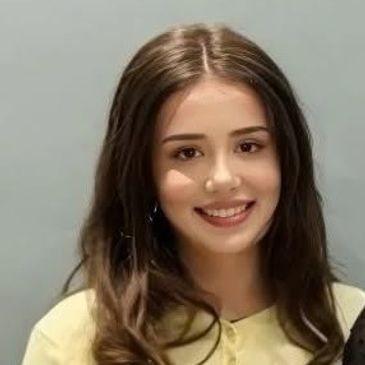 Young woman with brown hair smiling at the camera.