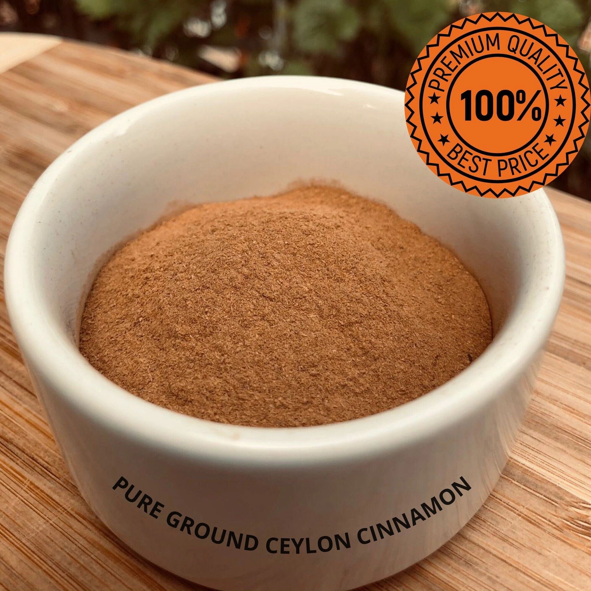A white bowl of fresh-ground Ceylon cinnamon powder on a bamboo board, labelled pure ground Ceylon cinnamon.