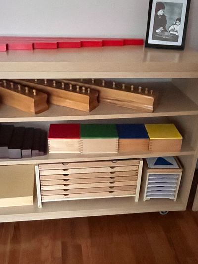 Montessori educational materials organized on shelves.