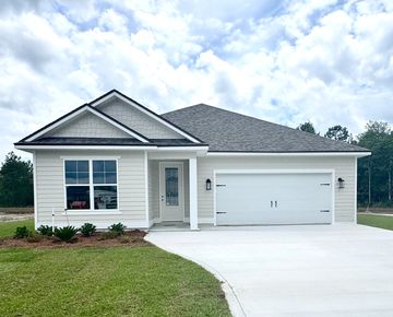 Modern single-story house with a two-car garage and manicured lawn.