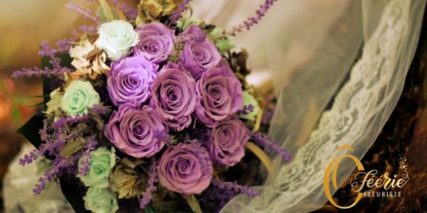 Bouquet de mariée fait de fleurs stabilisées. Roses lilas et petites roses menthes. Sur un voile. 